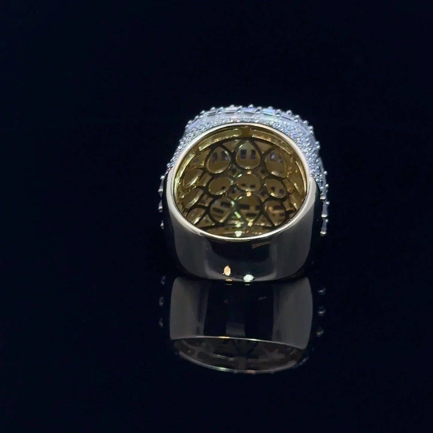 Gold and silver ring with intricate design on a black background